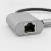 Gros plan sur la prise RJ45 de l'adaptateur, avec ses contacts dorés et son boîtier en aluminium gris