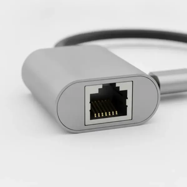 Gros plan sur la prise RJ45 de l'adaptateur, avec ses contacts dorés et son boîtier en aluminium gris