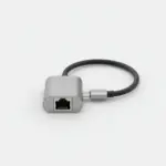 Adaptateur USB-C vers RJ45 en aluminium gris posé sur fond clair, prise réseau de face et câble court terminé par une fiche USB-C