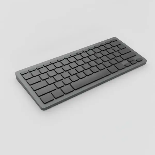 Clavier compact sans fil gris graphite vu de trois quarts sur fond gris clair, tranche fine visible