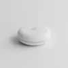 Détecteur de fuite d'eau rond et blanc, vu de face sur fond gris clair