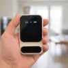 Boîtier Wi-Fi 4G tenu dans une main, vu de face, devant un salon lumineux flou