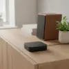 Récepteur Bluetooth posé sur un buffet en bois clair du salon, près d’une enceinte d’étagère
