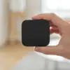 Récepteur Bluetooth tenu entre le pouce et l’index, pour donner l’échelle du boîtier